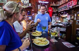 A server explains a dish to a couple seated at the bar of a Shreveport restaurant.