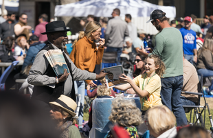 A child interacts with a festival host.