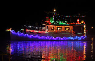 A boat is lit with Christmas lights